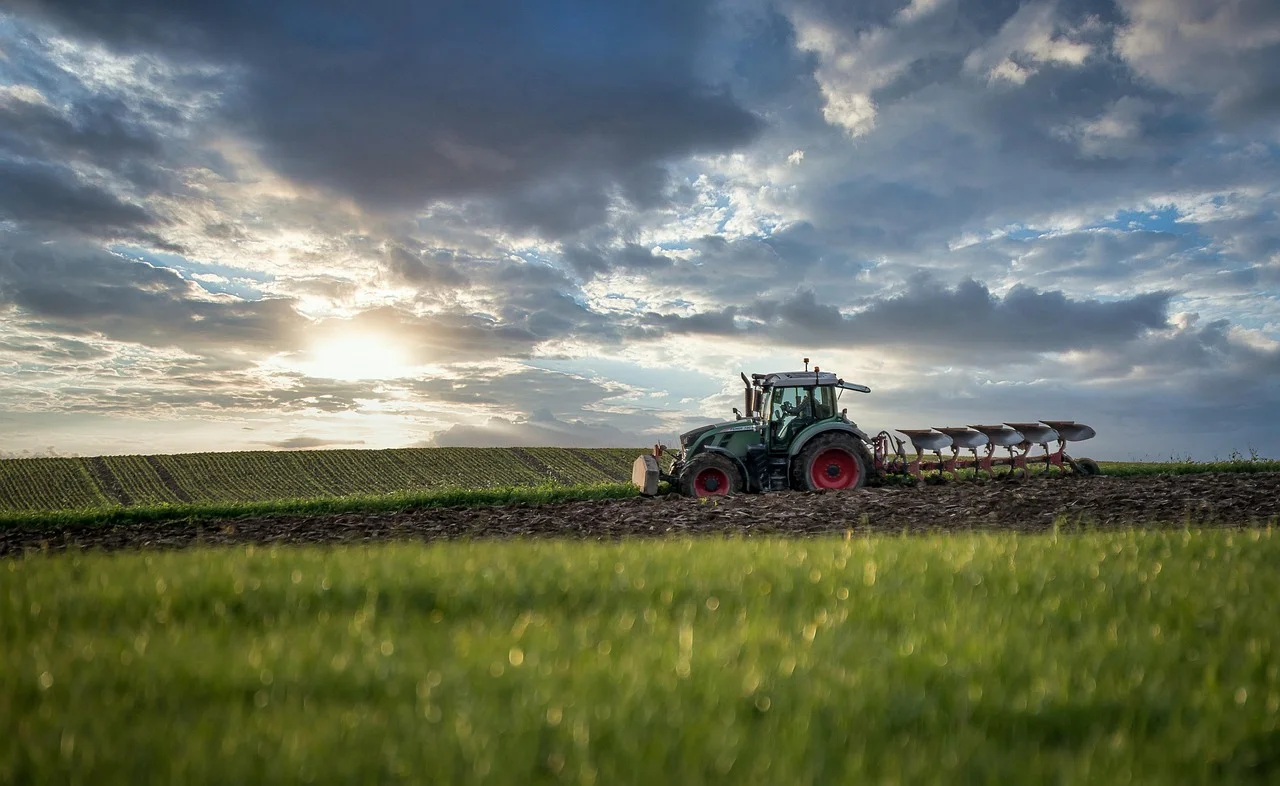 Agricultural tractor plowing field at sunset - R2D Fuel management systems for farming operations across Africa